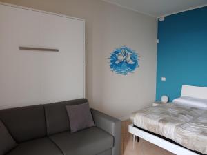 ein Schlafzimmer mit einem Sofa neben einem Bett in der Unterkunft La Finestra Sul Lago in Cernobbio
