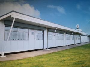 a white building with a gambrel roof at Sandhaven Beach Chalets in South Shields