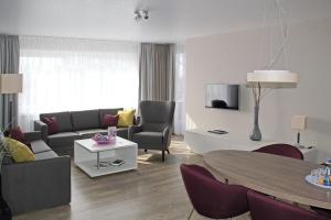 - un salon avec un canapé et une table dans l'établissement Upstalsboom Parkhotel, à Emden