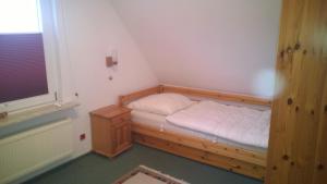 ein kleines Schlafzimmer mit einem Bett und einem Fenster in der Unterkunft Haus Seestern in Büsum