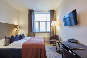 um quarto de hotel com uma cama, uma secretária e uma televisão em Hotel Vejlefjord em Stouby