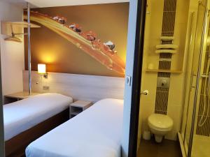 Cette chambre comprend 2 lits et des toilettes. dans l'établissement Hôtel Inn Design - Restaurant L'Escale, à Rochefort