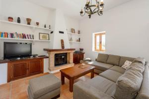un soggiorno con divano e camino di Villa Los Naranjos a Cala Llonga
