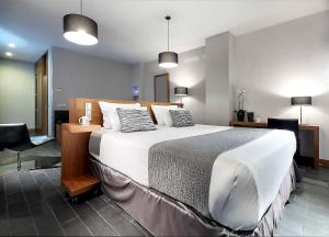 a bedroom with a large bed and a desk at Eurostars Madrid Congress in Alcobendas +70 photos
