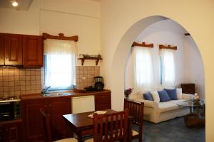 a kitchen and a living room with a couch and a table at Dolphin Studios in Astypalaia