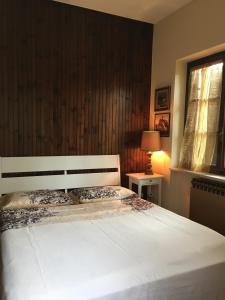 1 dormitorio con cama blanca y ventana en VILLA SECCHI, en Castrezatto