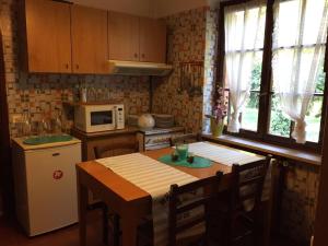uma cozinha com uma mesa com cadeiras e um frigorífico em VILLA SECCHI em Castrezatto