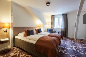 En eller flere senge i et værelse på Hotel Vejlefjord