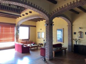 a living room with arched ceilings and a living room with red furniture at Villa Bonelli Bed & Fest in Savigliano