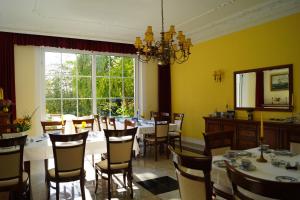 a dining room with tables and chairs and a large window at Hotel Villa Wittstock in Burg