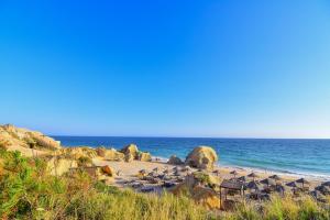 a beach with a bunch of rocks and the ocean at Bayside Salgados in Albufeira
