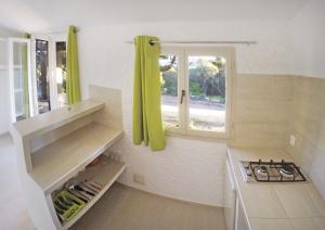 eine Küche mit einem Waschbecken und einem Fenster in der Unterkunft Village Naturiste La Chiappa in Porto-Vecchio