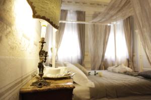 a bedroom with a bed and a table with a lamp at Residenza D'Epoca -Santa Caterina in Pisa