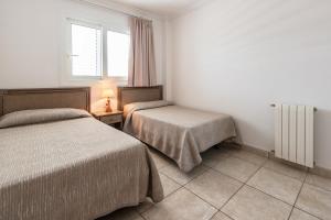 A bed or beds in a room at Apartamentos Es Cañe