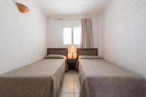 A bed or beds in a room at Apartamentos Es Cañe