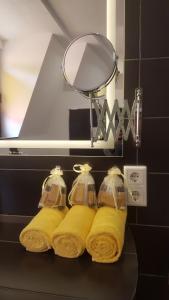 ein Badezimmer mit gelben Handtüchern auf einer schwarzen Theke in der Unterkunft Villa Renatus in Obernburg am Main