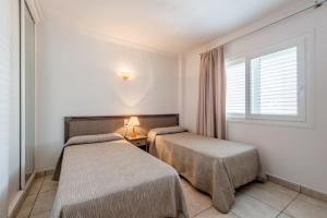 A bed or beds in a room at Apartamentos Es Cañe