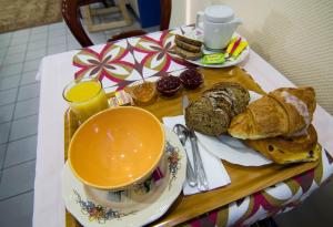 a table with a plate of bread and a cup of coffee at Hôtel de Bâle in Bantzenheim