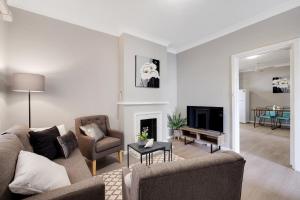a living room with two couches and a fireplace at Cute and Cosy - events, workers, getaways in Murray Bridge