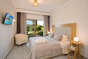 una camera da letto con un letto grande e una sedia di Venus Hotel a Kalamákion