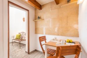 a kitchen with a wooden table and a chair at SA CASETA in Ciutadella +14 photos