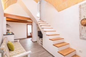 una scala in una camera con pareti bianche e pavimenti in legno di SA CASETA a Ciutadella
