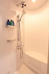 a shower with a glass door in a bathroom at NY Stage 新宿 in Tokyo