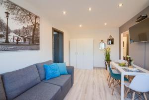 a living room with a blue couch and a table at Apartments 4 You Niepodległości in Tychy