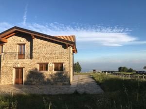 una casa de ladrillo en un campo junto a una valla en Rifugio Radura del Grano, en Plataci