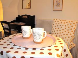 two coffee mugs sitting on a table with a piano at La Chambre d'Hôtes du Cladan in LʼÉpine