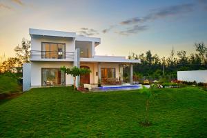 a large house with a lawn in front of it at Manna Villa in Mahabalipuram