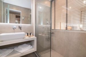un bagno con lavandino e doccia in vetro di Venus Hotel a Kalamákion
