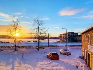 three cars parked in a parking lot in the snow at Hotell Linden in Östersund