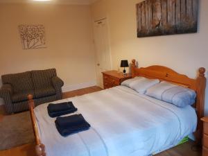 a bedroom with a large bed with two towels on it at Jesmond Vale 3 Bedroom Apartment in Newcastle upon Tyne