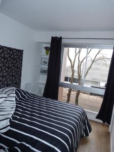 a bedroom with a bed and a large window at 33 Villa Curial in Paris