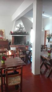 uma sala de jantar com mesas de madeira e uma lareira em B&B Bucaneve em Abetone