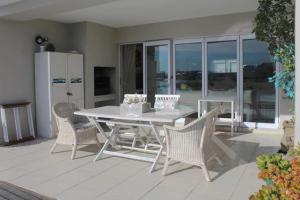 - une table et des chaises blanches sur la terrasse dans l'établissement Waterside Living KP08, à Jeffreys Bay