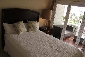 a bedroom with a bed with pillows and a balcony at Lantana Resort Barbados by Island Villas in Saint James
