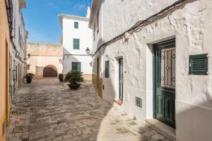 an alley in an old town with white buildings at SA CASETA in Ciutadella