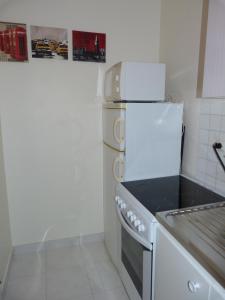 a kitchen with a white stove and a refrigerator at 33 Villa Curial in Paris