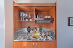 a kitchen with a sink in a wooden cabinet at Yalos rooms in Astypalaia