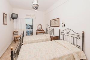 a bedroom with two beds and a tv in it at Yalos rooms in Astypalaia