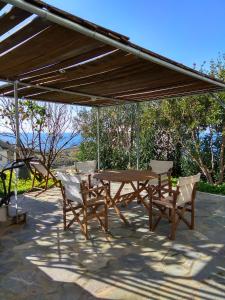 a wooden table and chairs under a canopy at Garden house Karystos in Karistos