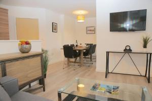 uma sala de estar com uma mesa e uma televisão na parede em Wilford View em Nottingham