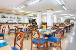 a restaurant with wooden tables and blue chairs at Globales Acuario in Puerto de la Cruz