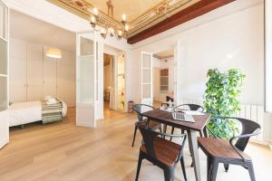 a dining room with a table and chairs and a bedroom at Bravissimo Plaça del Vi, Authentic Historic Apartment in Girona