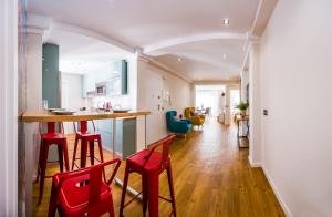 una cucina con sedie rosse e un bar in una stanza di Expoholidays-Rueda Lopez apartamento de lujo a Almería