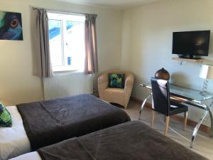 a bedroom with a bed and a desk and a television at Castle Sleeper in Corby