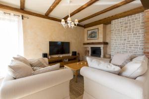sala de estar con muebles blancos y pared de ladrillo en Luxury Villa Nika en Dobrinj