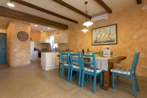 een keuken met blauwe stoelen en een tafel in een kamer bij Luxury Villa Maša in Dobrinj